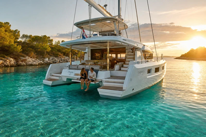 Luxury crewed catamaran anchored in a Croatian cove at sunset