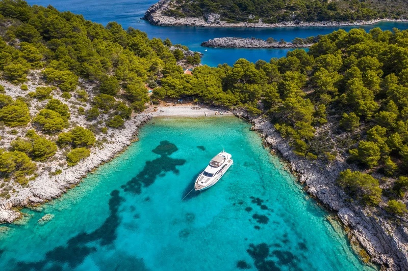 Aerial view of yacht in a turquoise Croatian island cove